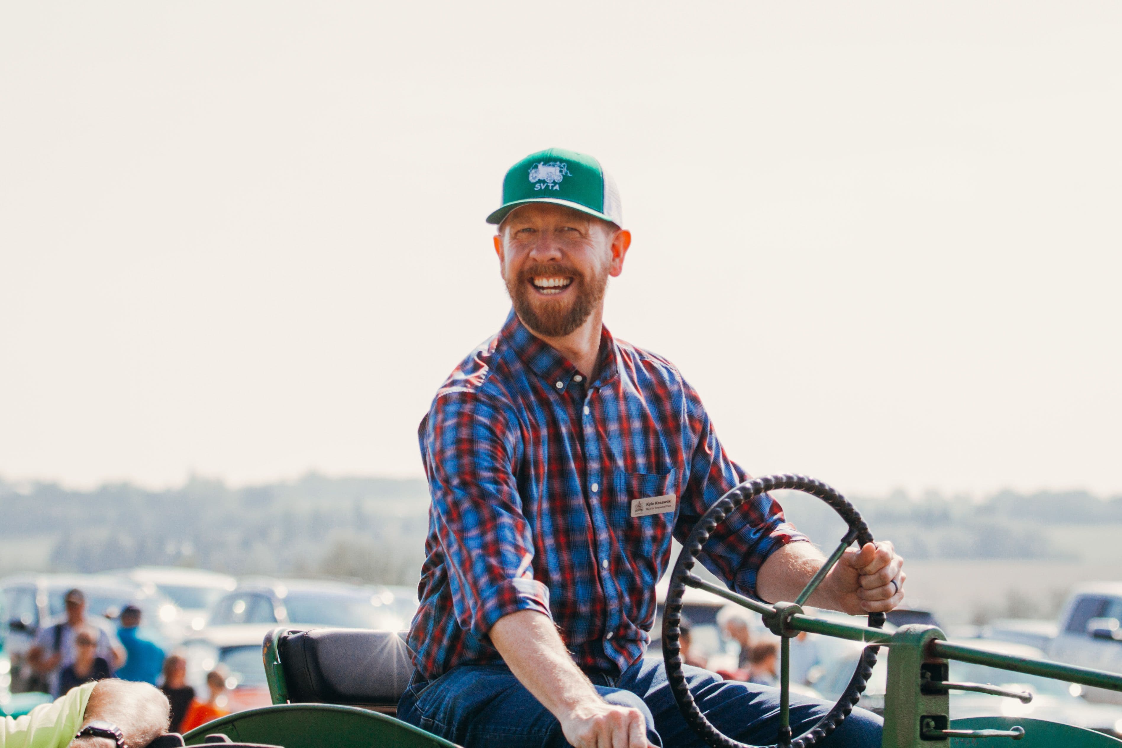 Kyle Kasawski, MLA for Sherwood Park, sitting on a vintage tractor at the Strathcona Vintage Tractor Association annual event